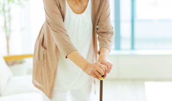 杖で歩く高齢者